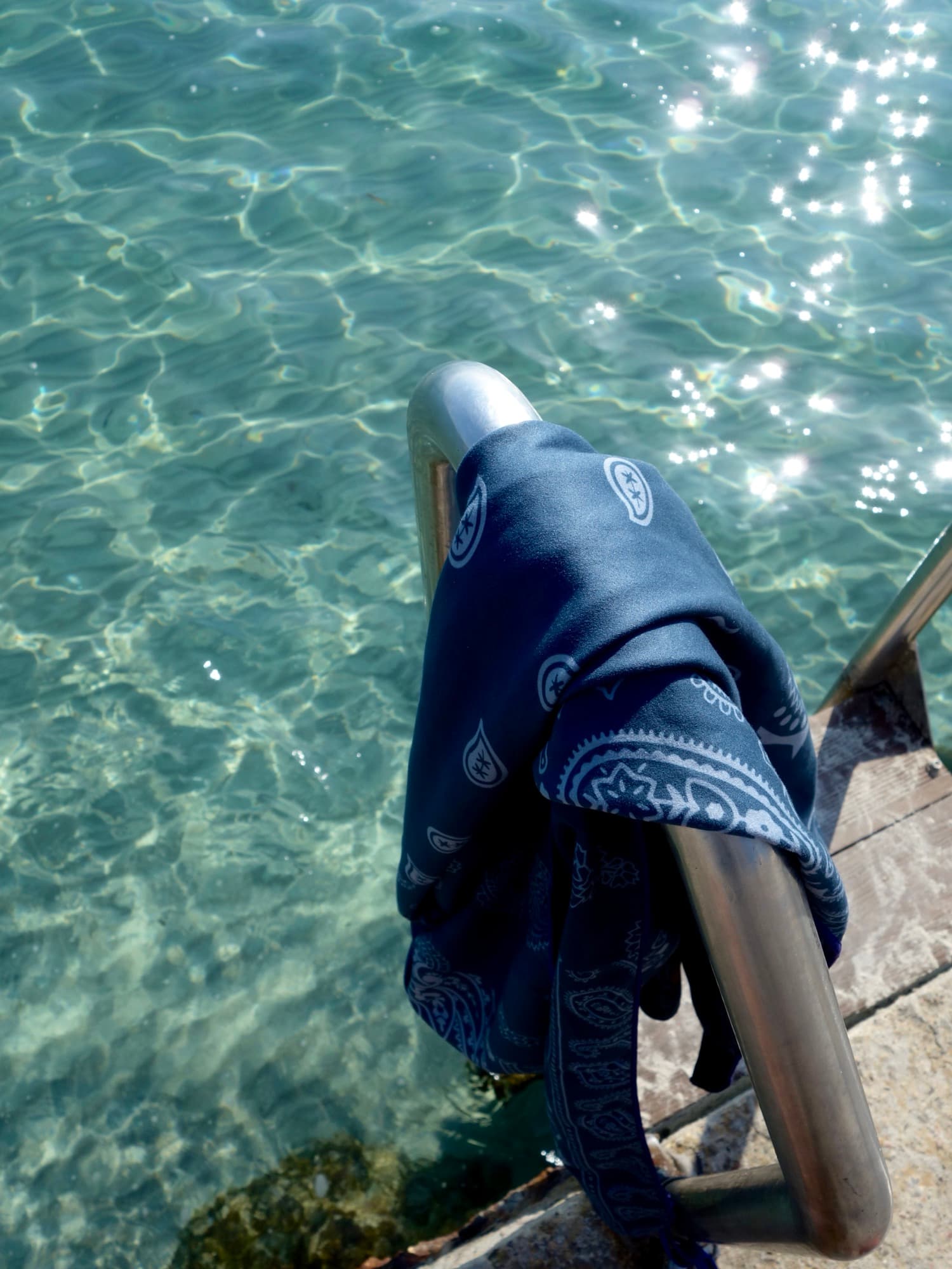 A Sèche bandana towel drying on the pool ladder, Côte d'Azur