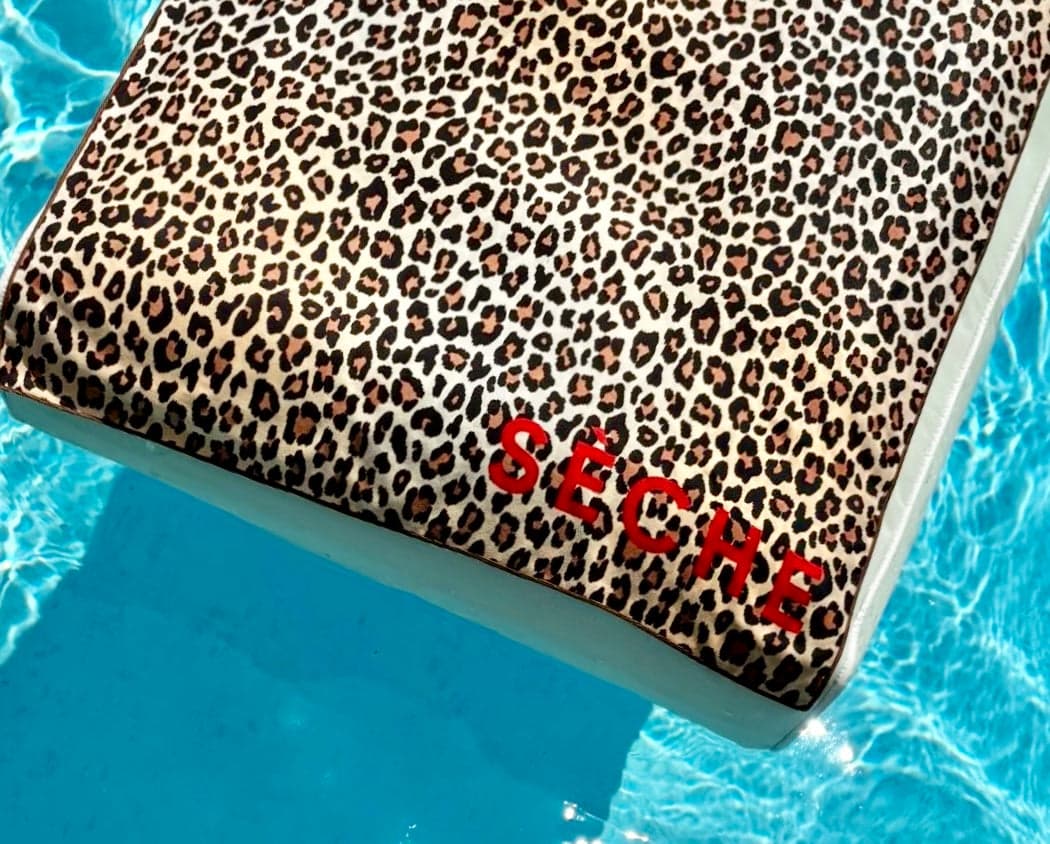 A Sèche leopard towel floating in the pool